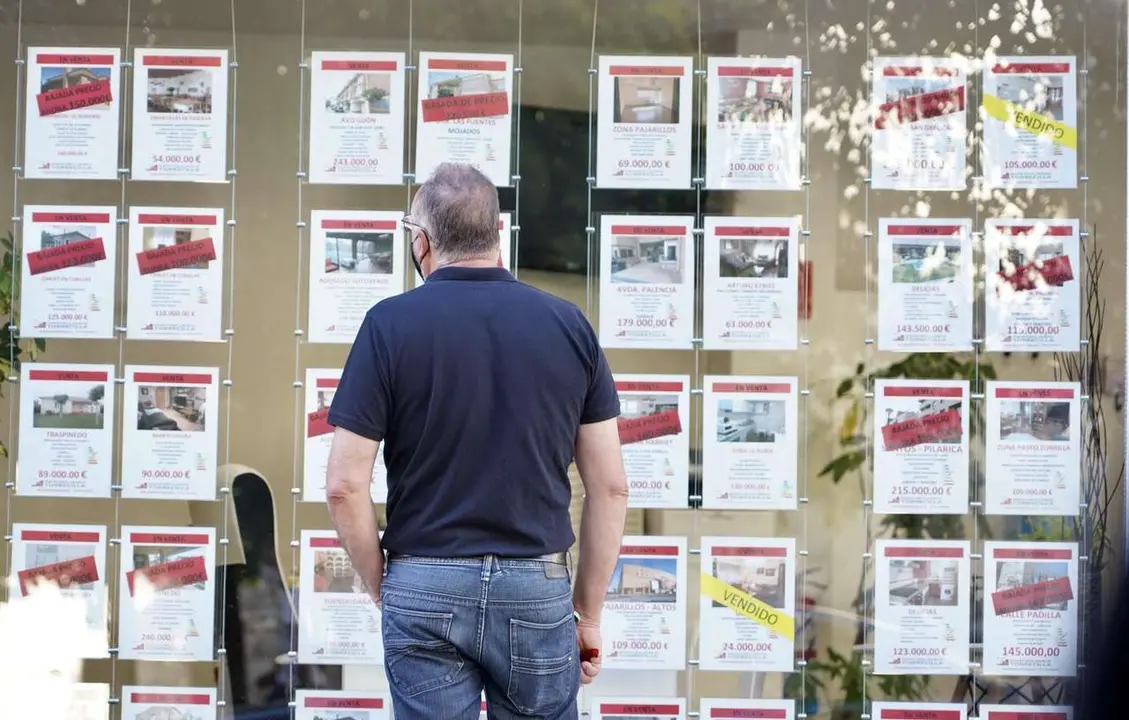 Un hombre observa los anuncios de pisos en venta y alquiler en una inmobiliaria. / ICAL