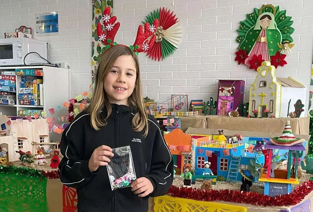 Adriana con una de sus pulseras hechas a mano frente al bel&eacute;n de la Sala de Juegos de Pediatr&iacute;a de la Gasbi.