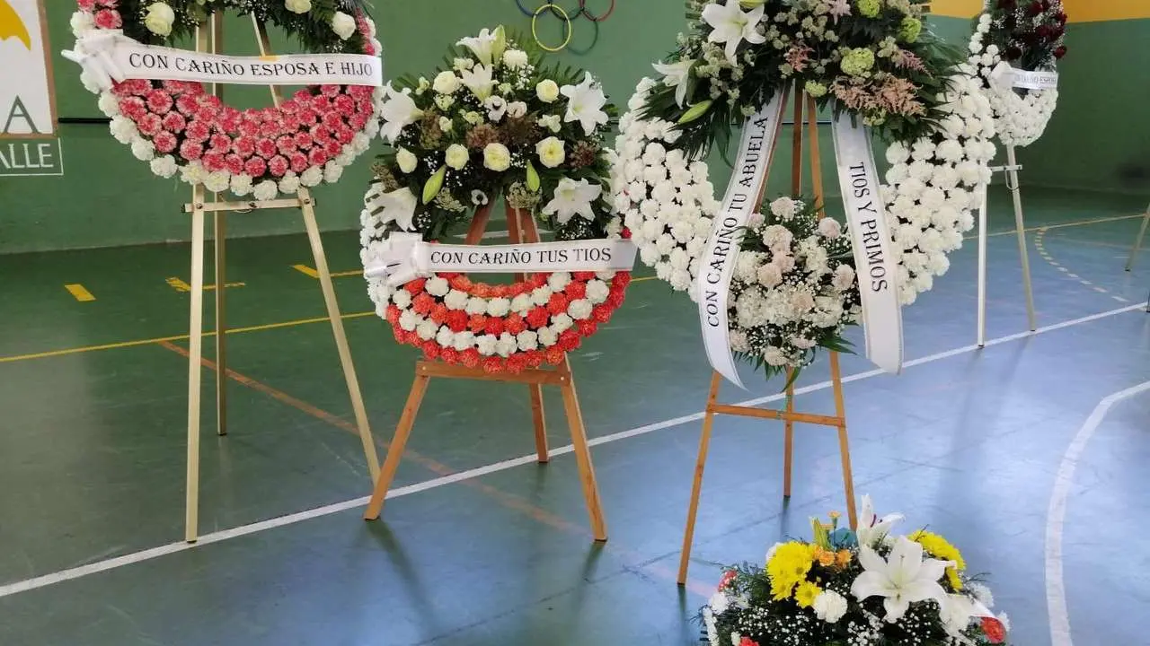Coronas de flores en recuerdo de los mineros fallecidos llenan el Polideportivo de Villablino este martes. / LEON24HORAS