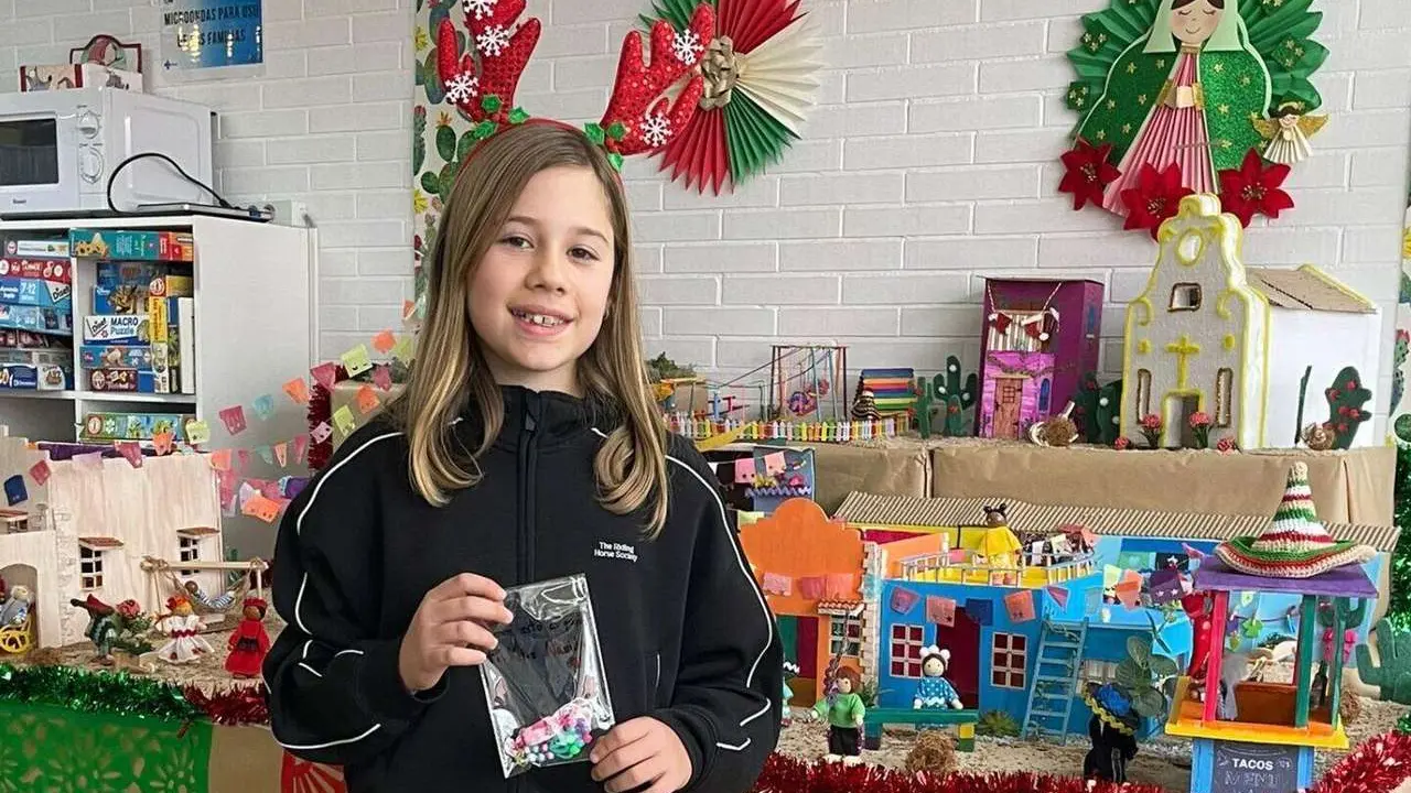 Adriana con una de sus pulseras hechas a mano frente al bel&eacute;n de la Sala de Juegos de Pediatr&iacute;a de la Gasbi.