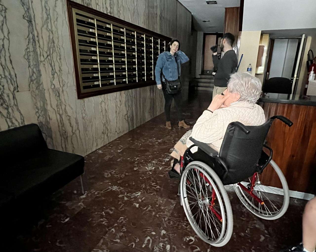 En la imagen, una mujer en silla de ruedas no puede acceder a su vivienda.